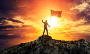 Businessman With Flag On Mountain Top. Concept For Success. - Contabilidade Digital para todo o Brasil | GG Contabilidade